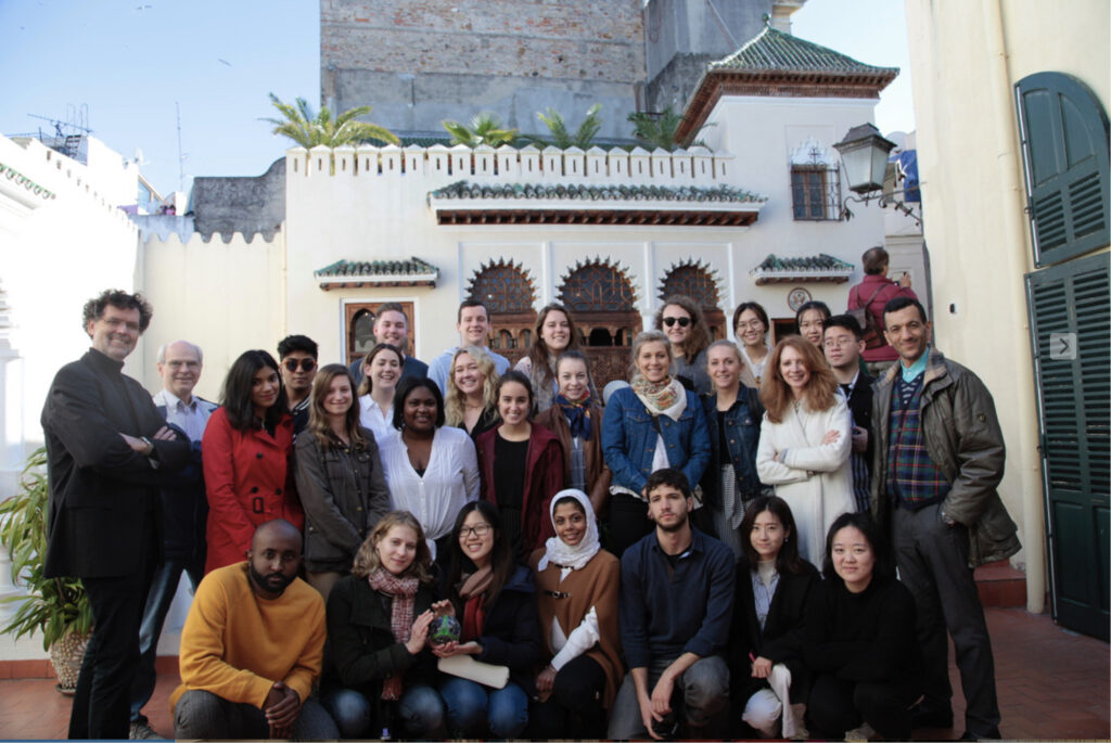 Color photograph, group of men and women standing on one of the terraces overlooking a courtyard in the Old American Legation in Tangier.