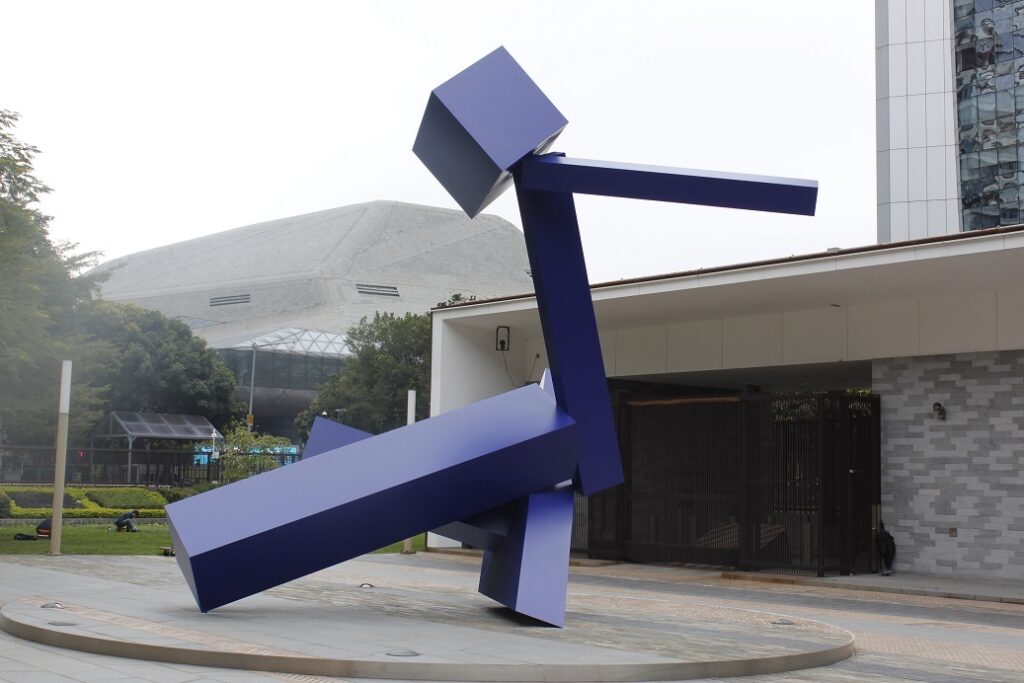 Guangzhou - Consulate - NOW sculpture by Joel Shapiro. Color photograph of abstract sculptural form. The artwork is crafted in metal and painted blue.