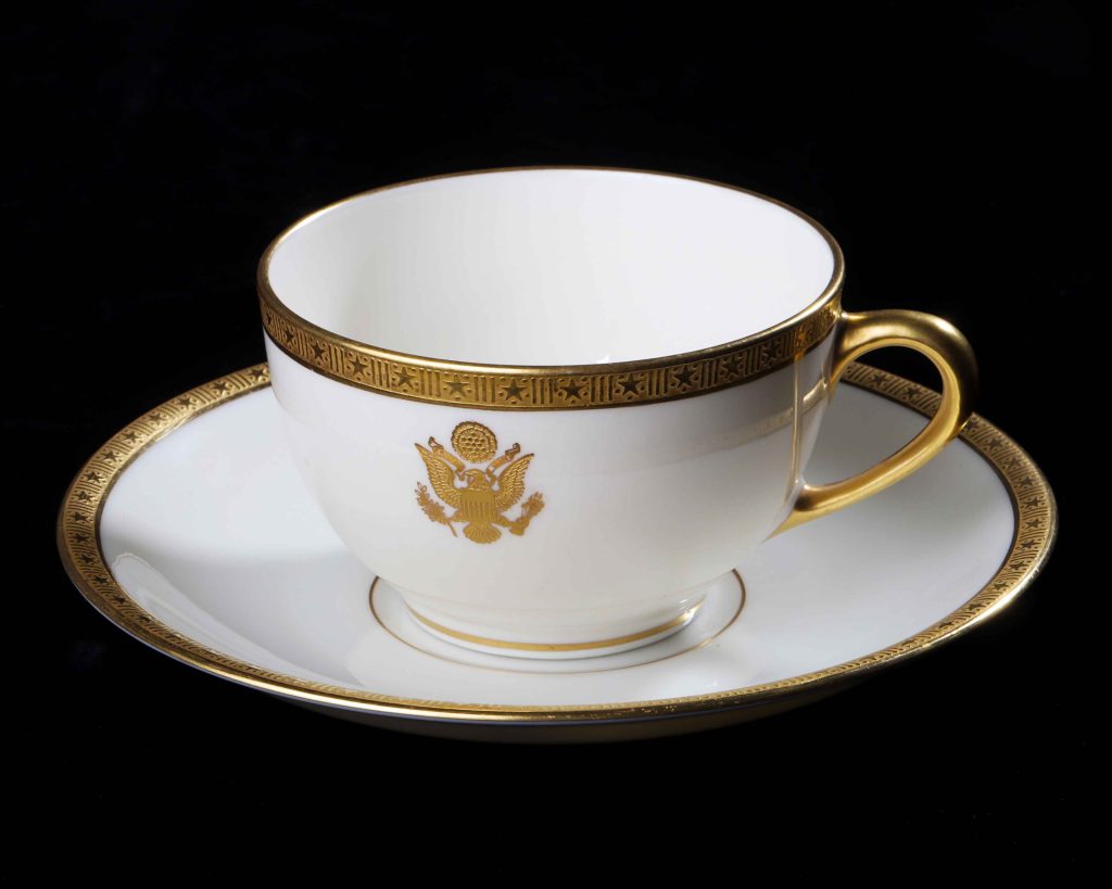 Bone china dinnerware, circa 1925

U.S. Embassy Warsaw, Poland

Lenox Corporation

American, founded 1889

This official china dinnerware dates to 1925, when John B. Stetson, Jr., son of the hatmaker, was appointed by President Calvin Coolidge to serve as U.S. Minister to Poland. He ordered custom-made china dinnerware bearing the American eagle and stamped with his name from the Lenox company of New Jersey. Walter Scott Lenox (1859-1920), a pioneering American inventor, had created bone china rivalling that of Europe. President Woodrow Wilson had ordered Lenox china dinnerware for the White House in 1918––the first American-made presidential china––likely influencing Stetson’s purchase.

Stetson’s chinaware was used by his ambassadorial successors in Warsaw from the Roaring Twenties until the Internet Age, surviving the Nazi occupation and the upheaval of the communist era. The elegant antique china is a reminder that fragile objects, like peace among nations, can be preserved if properly cared for.

Gift of Ambassador John B. Stetson, Jr., circa 1929
