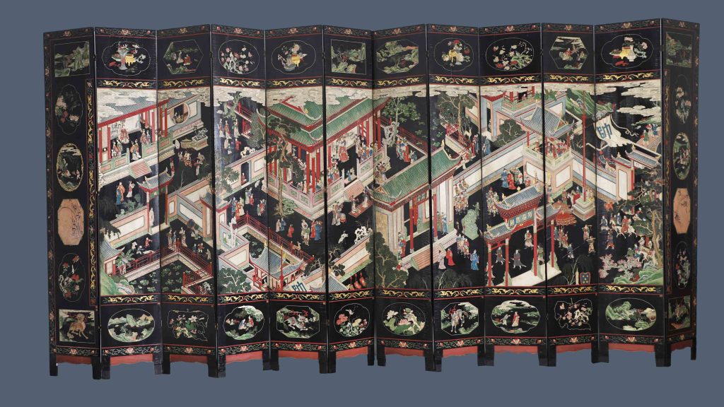 Twelve lacquered wood panels with silk lining, “King Long” Period, 18th century

U.S. Embassy Brussels, Belgium

This elaborate, oversized wall screen, depicts an imperial tableau from the prosperous “long” reign of the Kangxi Emperor (1661-1722). Within a grand palace, people move about as merchants peddle wares, children play, and musicians serenade. Gifts and offerings are presented to the Lord and his lady. The reverse encloses panels of silk with gilded calligraphy.

The screen was made using the ancient Chinese kuan kai (literally “incised colors”) lacquer technique that was first developed in the ancient Song Dynasty, then revived and adapted for the European export trade beginning in the late 16th century, Given their size and grandeur, Coromandel screens are often displayed in an entrance hall or to divide large rooms.

Coromandel refers to the Coromandel Coast of south-east India, from which such works were exported to Europe by the Dutch East Indies Company and by its rivals from other European companies who had bases there.

This 18th century piece is displayed in the Ducale Room at the U.S. Ambassador’s residence in Brussels, Belgium.
