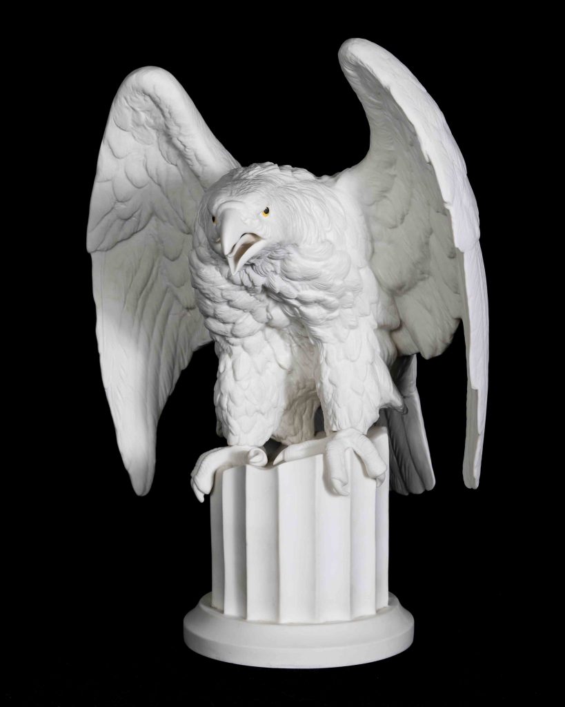 Hand-painted porcelain and colored glass, circa early-to-mid 20th century

U.S. Embassy London, United Kingdom

Edward Marshall Boehm

American, 1913-1969

A Baltimore, Maryland native, Edward M. Boehm was a largely self-taught figurative expressionist sculptor who specialized in hard paste porcelain figures of birds and wildlife. His work is displayed in the permanent collections of 134 institutions globally, including the White House, Smithsonian, Buckingham Palace, The Vatican, the Hermitage, and the Museum of Modern Art in New York City.

He is the only American to have a wing named after him at the Vatican Museum.

This eagle was a gift from Boehm to the U.S. Embassy in London to honor President John F. Kennedy in 1961. The gift may have been prompted by the President’s visit to London in June of that year with First Lady Jacqueline Kennedy.

Boehm’s decision to depict an eagle may have also been an homage to the two-ton golden-hued aluminum sculpture of a bald eagle created by fellow American artist, Theodore Roszak, and set atop the then-new U.S. Embassy in London. The building, which opened in 1960 and was decommissioned in 2018, was designed by noted American architect, Eero Saarinen.
